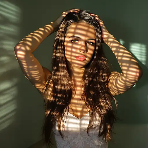 Full body portrait of a brunette woman in a white lace dress, captured in warm afternoon light with shadows across her face.