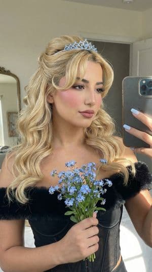 A stylish mirror selfie featuring a coquette style with elegant attire and soft lighting.